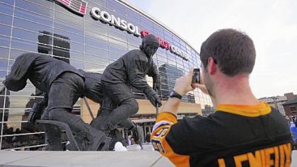 Brian Smith of Canonsburg takes a photo of his hockey idol's statue Wednesday before the Penguins game with Toronto.