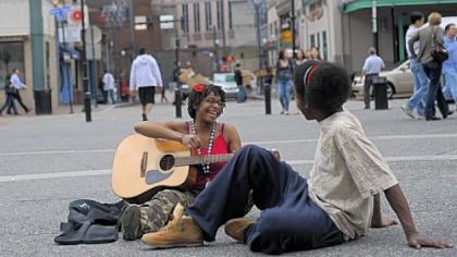 Rachel Lyons, left, taking advantage of a  great day,  sings a song with words Justin Williams gives her in Market Square.