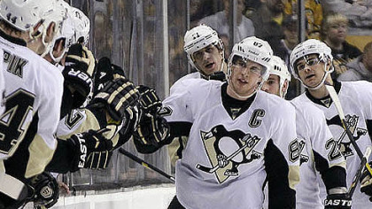 Penguins center Sidney Crosby leads his team to the bench to celebrate his goal last night against the Boston Bruins.