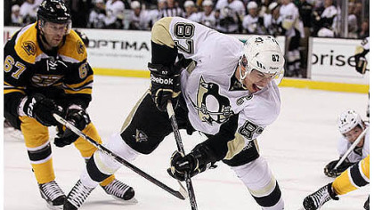 Sidney Crosby, who had two goals, beats Boston's Benoit Pouliot en route to the net Tuesday night in Boston.