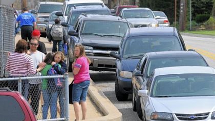 Traffic piles up Tuesday on Scott Avenue outside Shaler Elementary School while students comfort each other. An air handler unit pipe fell from the ceiling, resulting in injuries to 12 students and faculty members.