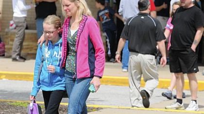 A distraught student and parent leave Shaler Area Elementary School. An air handler unit pipe fell from the ceiling Tuesday, resulting in 12 injuries there.