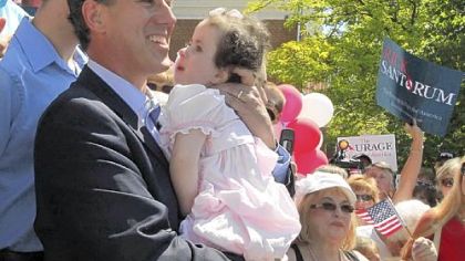 In this June 6, 2011, file photo, former Pennsylvania Sen. Rick Santorum holds his daughter Isabella before announcing he is entering the Republican presidential race.