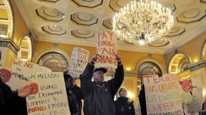 One Pittsburgh protesters chant in the lobby of the Omni William Penn during the BNY Mellon's shareholder meeting Tuesday.