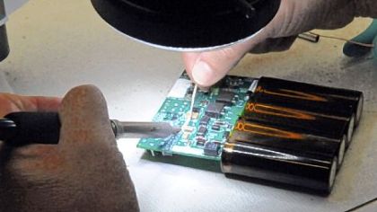 Chris Couts uses a microscope to make tiny welds on a defibrillator circuit board at Zoll Medical in the RIDC Park in O'Hara.