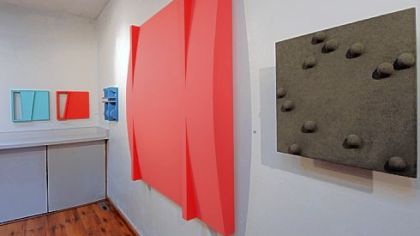 A view of the exhibition "David A. Ludwig: Structures" includes an example of his most recent work, right, with added found objects incorporated onto the surface.