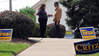 Election workers Tracy McDonough, left, and Ash Marwah spend their idle time in conversation outside the polling place at the Franklin Park Municipal Building today.