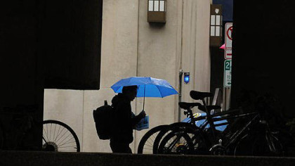 A student walks  between the Barco Law Building and the David Lawrence Hall  along Forbes Avenue on the University of Pittsburgh campus.