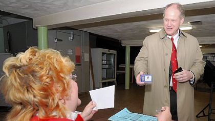 Congressman Mark Critz shows his photo ID to Kelly Swanson, minority inspector at precinct 17-2, as he prepares to vote Tuesday in Johnstown, Cambria County.