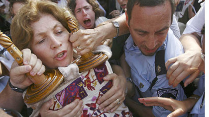 Anat Hoffman, left, chairwoman of the Women of the Wall organization, holds onto a Torah scroll as Israeli police attempt to take it from her and detain her, outside the Western Wall, Judaism's holiest site, in 2010.
