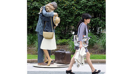 A pedestrian passes Seward Johnson's painted bronze sculpture, "Contact," in Gateway Center.