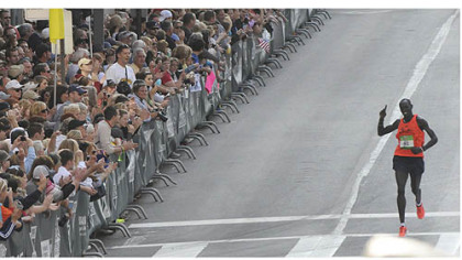 James Kirwa of Kenya waves to the crowd along the Boulevard of the Allies as he heads to the finish line.