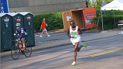 The early marathon leader, Nixon Kiplagat, passes WQED on Fifth Avenue.