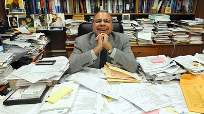 Duquesne University professor of medicinal pharmacy Aleem Gangjee and an ocean of paperwork.