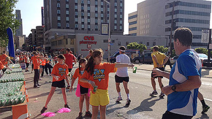 Volunteers hand out water to marathon runners along Forbes Ave.