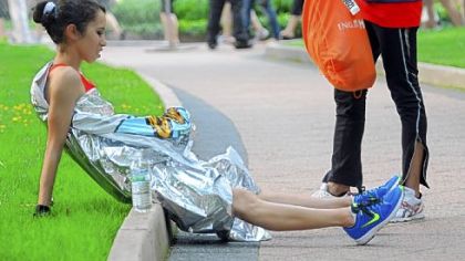 Women's winner Malika Mejdoub of Morocco stretches her leg muscles shortly after she finished, with a time of 2:39:30.