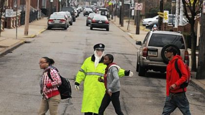 Crossing guard Cathy Gamble directs students across the 44th at Butler Street intersection in Lawrenceville during the morning commute.