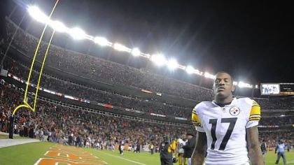 Receiver Mike Wallace walks off the field Sunday after losing to the Broncos in overtime at Sports Authority Field at Mile High in Denver.
