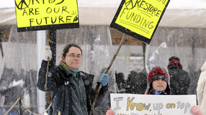 Karen Crow from Stanton Heights and her daughter, Dorothy, 8, greet protestors arriving at the Yinzer Nation Rally to protest Governor Tom Corbett's education budget today at Schenley Park Plaza.