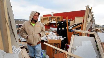 Clinton Patrick stands in what is left of his father's home after it was destroyed by a tornado March 3 in Holton, Ind.