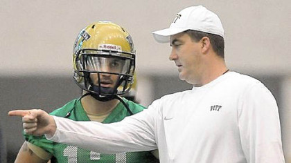 New Pitt football coach Paul Chryst, right, works with Tino Sunseri on the first day of spring practice Thursday.
