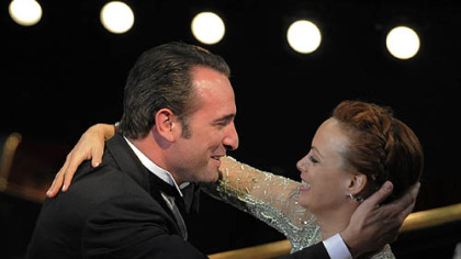 Jean Dujardin is congratulated by Berenice Bejo before accepting the Oscar for best actor for "The Artist."