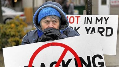 Sue Morrow of Butler joins protesters gathered Thursday in downtown Butler to oppose Rex Energy Marcellus Shale drilling and demand that clean water be restored in their Connoquenessing Township community.
