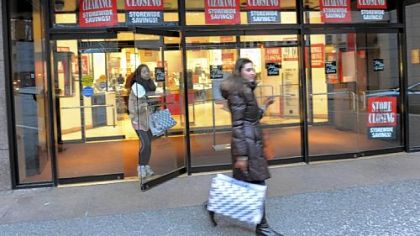 Saks windows display clearance signs of 30-60 percent off merchandise.