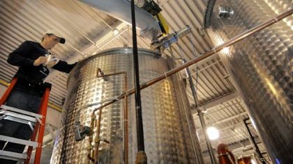 Wigle Whiskey co-owner Mark Meyer adds enzymes to cooking mash at the distillery.