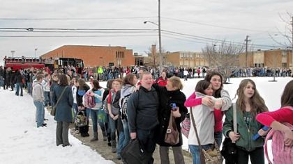 Chardon High School students file out of the school, at rear, for pickup by their parents after Monday's shooting in Chardon, Ohio.