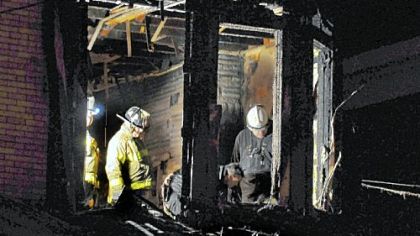 Officials investigate the cause of a double fatal fire at a home on Graham Street in Friendship.