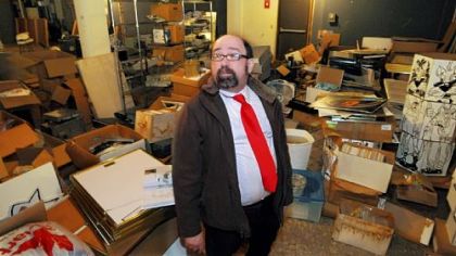 Joe Wos, executive director of the ToonSeum, Downtown, looks over comics, displays, books and other material damaged by a recent leak in the museum's North Side warehouse.