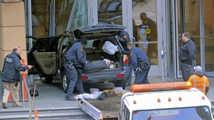 Police check the SUV that careened up the steps of the PNC First Side Center building Downtown today.