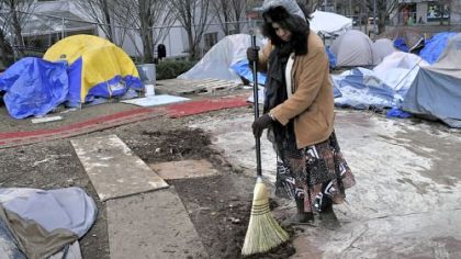 Celeste Taylor, who participated in the first Occupy Pittsburgh march in 2011 and who has stayed at the site about 10 times since then, cleans up the area Thursday where one of the tents was removed because of its condition.