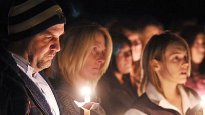 Michael Schaab's family attends a vigil marking his killing. From left are his father, Harry, his mother, Mary, and his fiancee, Megan Shively.