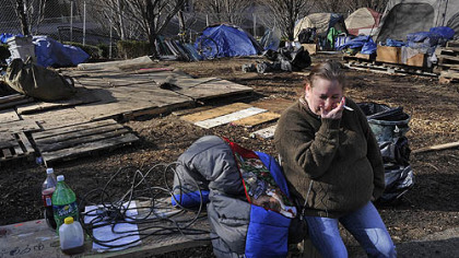 A member of the Occupy Pittsburgh movement sits on a bench with her belongings as the encampment on BNY Mellon's property is dismantled.