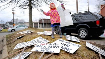 Gretta Boerner, 6, of New Wilmington, asks protesters gathered to pick up signs during the Rex Energy protest.