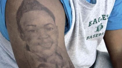 Jamil Pollard shows the tattoo of his slain sister, A'aliah Scott, on his arm. An image of his second sister, India Duncan, is on his other arm.