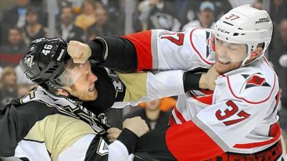 Joe Vitale, left, takes a right from Carolina's Tim Brent in the third period Tuesday at Consol Energy Center.