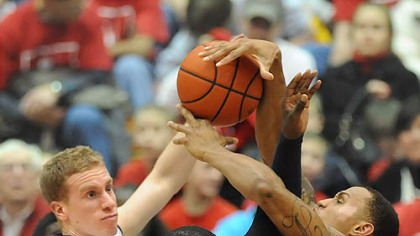 Duquesne's Eric Evans, middle, and a teammate battle Richmond's Josh Duinker for a rebound in the first half Saturday at Palumbo Center.