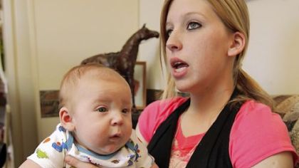 Sarah McKinley, 18, and her 3-month-old son Justin sit on the couch of her mobile home Wednesday in Blanchard, Okla. Ms. McKinley's son was with her Saturday when she shot Justin Shane Martin, 24, after he broke into her home. Authorities don't plan to file charges against her.