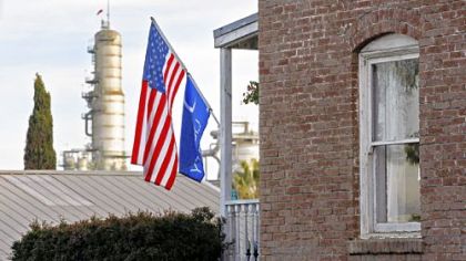 An old brick building on Richmond Street flying an American flag has a view of the Chevron El Segundo Refinery from the historic downtown of El Segundo, which is in its 101st year. After decades of mostly prosperous times for the city and the oil company, El Segundo is having a falling-out with its longtime benefactor.