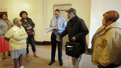 George Moses of the Housing Alliance of Pennsylvania (second from right) meets with tenants of a condemned apartment building on McClure Avenue in Swissvale.
