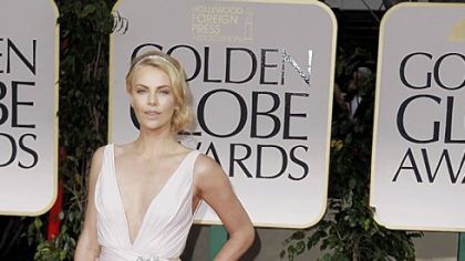 Charlize Theron exuded soft sex appeal in a pale plunging dress.