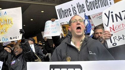 Demonstrators outside the David L. Lawrence Convention Center, including ATU Local 85 operators Sarita Allen, left, and Tim Bell, right, chant slogans about the absence of Gov. Tom Corbett as hearings into cutting the transit system were taking place inside.