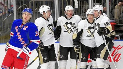 Chris Kunitz, second from right, celebrates with teammates after scoring a goal in the first period Thursday as the Rangers' Ryan Callahan, left, skates away at Madison Square Garden in New York.