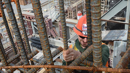 Robert Hutchison adjusts steel reinforcing bars that will form the shells for the Olmsted dam. The network of steel is encased in concrete before being lowered into the river.