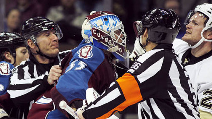Avalanche goalie Jean-Sebastien Giguere is restrained from going after Matt Cooke, right, in the second period Saturday night in Denver. A penalty was called on Giguere for striking Cooke on the play.
