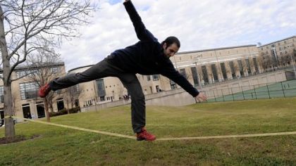Ahmet Sahinoz, 22, a graduate student of mechanical engineering at Carnegie Mellon University, practices his balance on a slacklining rope on Tuesday, when the temperature reached 60 degrees, 24 degrees above normal.