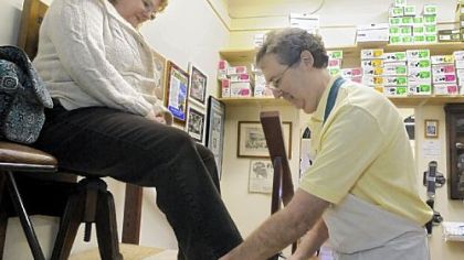 Gene Rosen fits customer Patti Smutko of Cranberry with a pair of orthotic Alegria shoes.